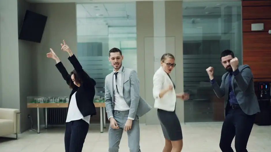 Group of business professionals dancing in modern office setting, expressing joy.
